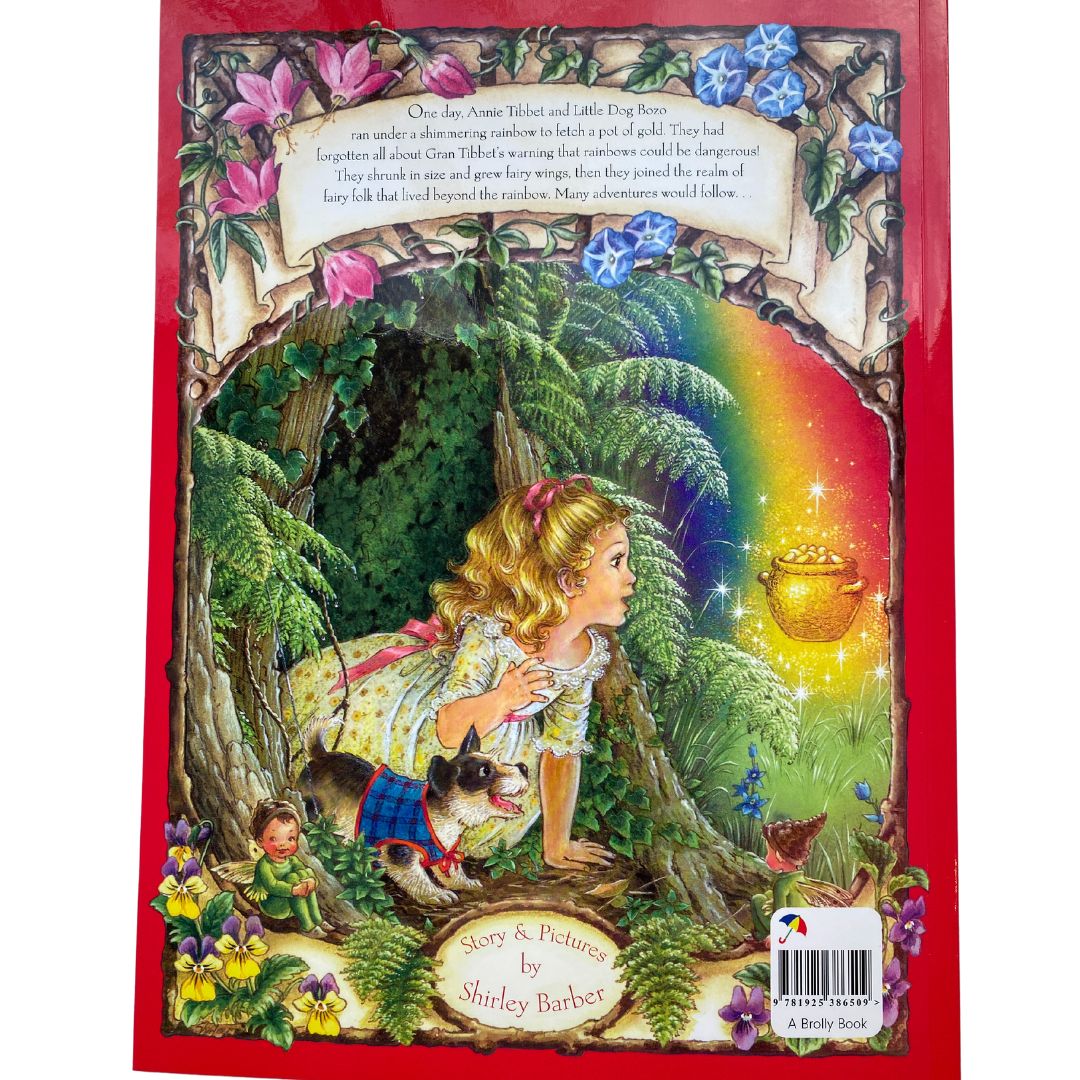 The back cover of A Rainbow Magic by Shirley Barber . A young girl looks out from a tree to find a pot of gold at the bottom of a rainbow.