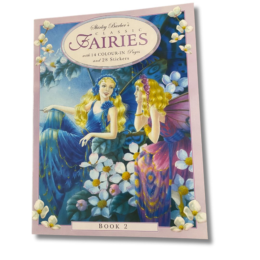 Cover of shirley barbers fairies colour in book 2 two fairies are having a conversation both have blonde hair. One has a blue ball gown on and blue butterfly wings and the other has a pink ball gown with pink butterfly wings they are surrounded by small white flowers 