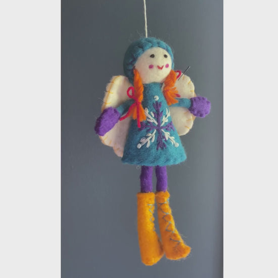 Video of a tara treasures felt fairy with a blude dress, purple legs and hands and yellow boots 